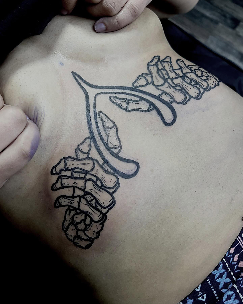 Fine line skeleton hands and wishbone, by Kevin Lewis