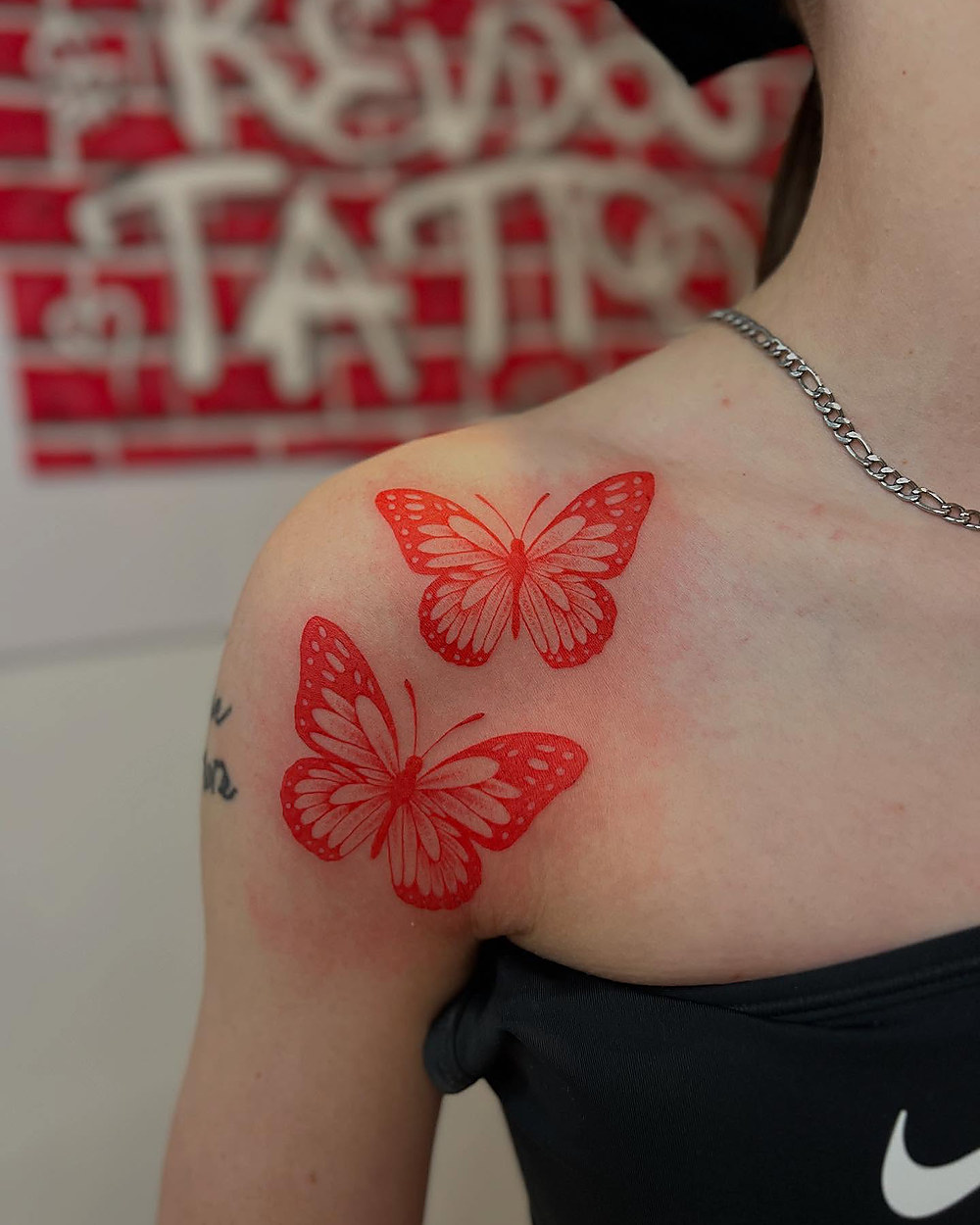 Red ink butterflies on a shoulder, by Kevin Lewis