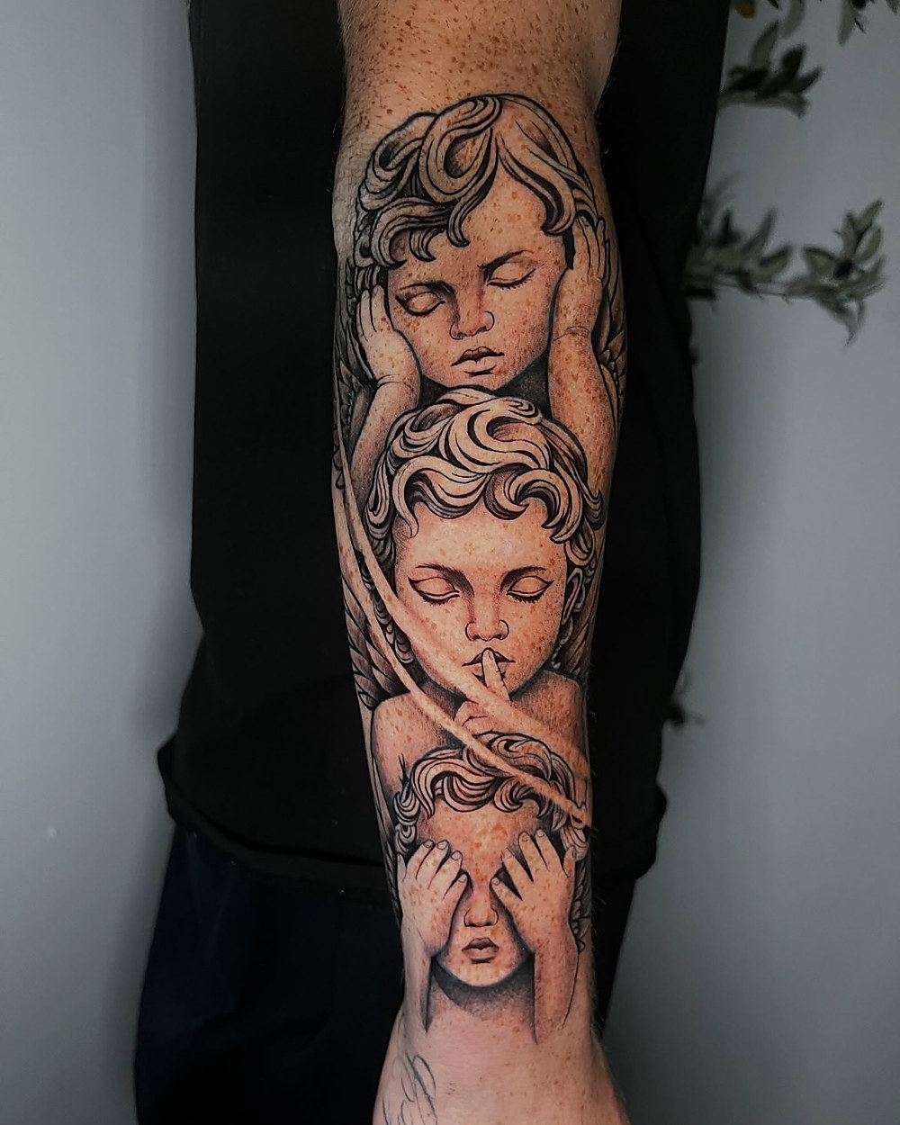 Cherub faces down a forearm, by Kevin Lewis