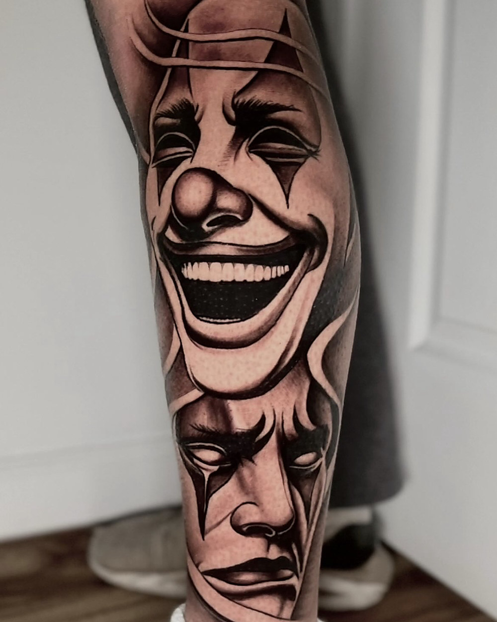 Comedy and tragedy masks on a calf, by Kevin Lewis