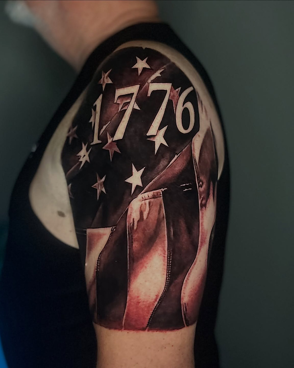 A 1776 flag shoulder piece in black and grey, by Owen Lewis