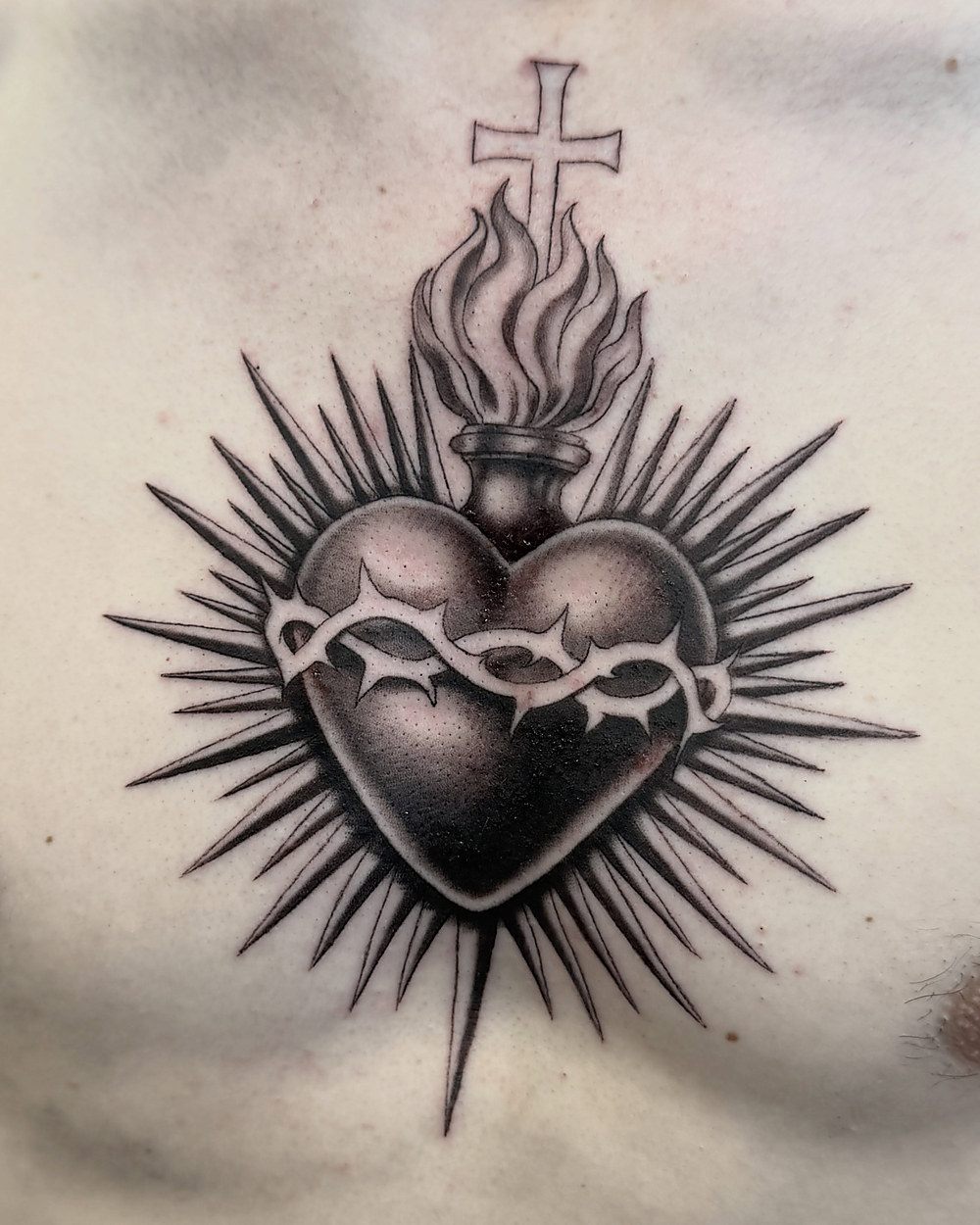 Sacred heart chest piece in black and grey, by Owen Lewis