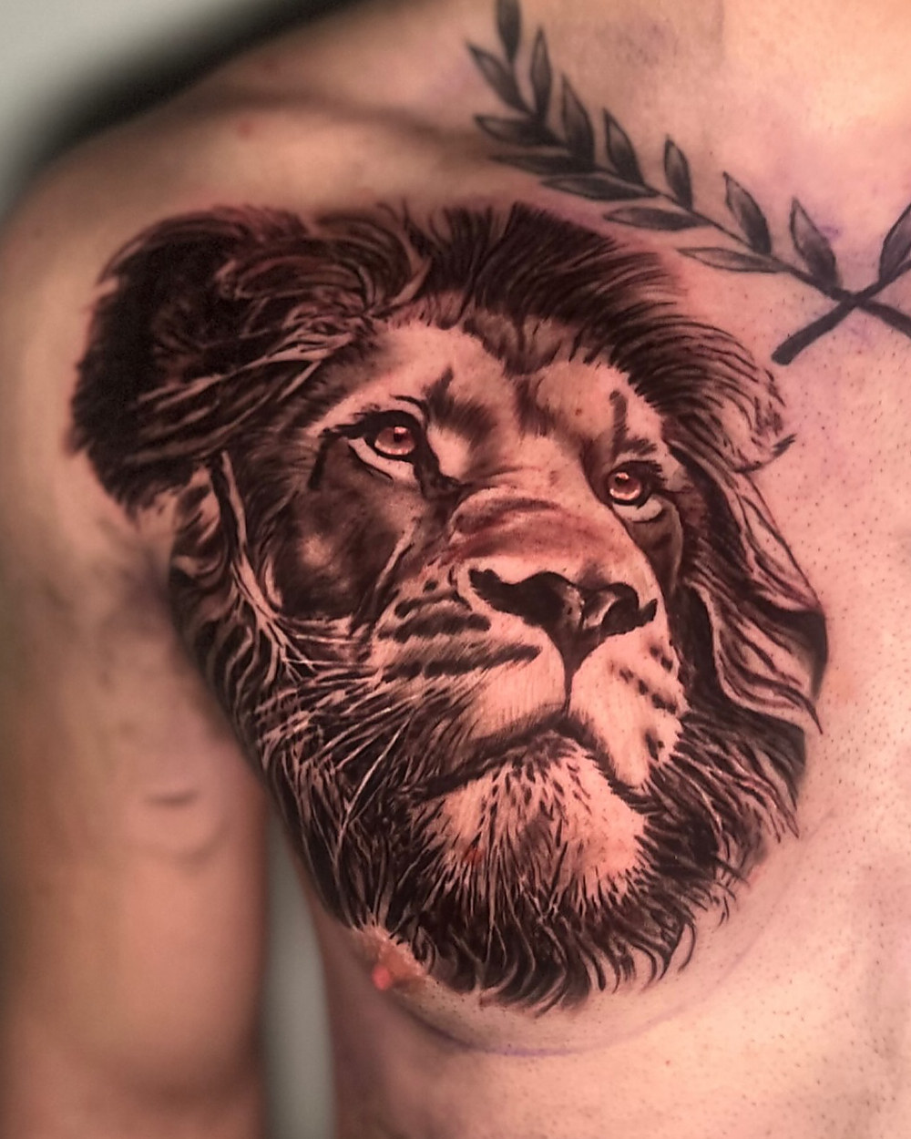 Lion chest piece in black and grey, by Owen Lewis